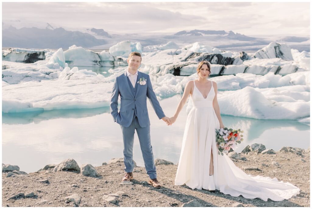 A couple holding hands on during their elopement at Jkulsrln Glacier Lagoon in Iceland.