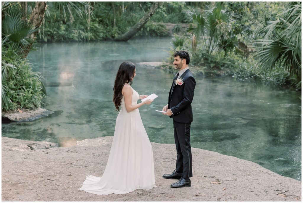 Bride and Groom sharing vows while standing on a rock at a misty Florida Spring during sunrise.